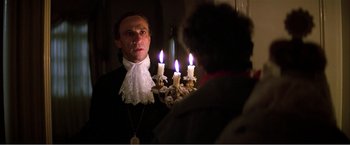 Movie still from “Amadeus” (1984), directed by Milos Forman – A man wearing a white shirt and a black and white tie; Medium shot, Over the shoulder angle