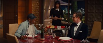 Movie still from “Kingsman: The Secret Service” (2014), directed by Matthew Vaughn – Two people sitting at a table with a tray of food; Medium shot, Over the shoulder angle