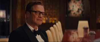 Movie still from “Kingsman: The Secret Service” (2014), directed by Matthew Vaughn – A person wearing a suit and bow tie; Close Up shot, Over the shoulder angle