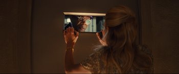 Movie still from “Kingsman: The Secret Service” (2014), directed by Matthew Vaughn – A woman taking a picture of a man with glasses in a mirror; Close Up shot, Over the shoulder angle