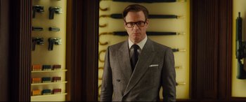 Movie still from “Kingsman: The Secret Service” (2014), directed by Matthew Vaughn – A man in a suit and tie standing in front of a mirror; Medium shot, Over the shoulder angle
