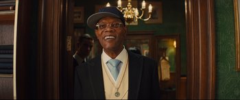 Movie still from “Kingsman: The Secret Service” (2014), directed by Matthew Vaughn – An older man wearing a hat and a tie; Close Up shot, Over the shoulder angle