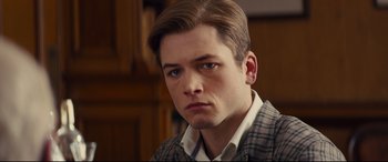 Movie still from “Kingsman: The Secret Service” (2014), directed by Matthew Vaughn – A person wearing a suit and tie; Close Up shot, High angle