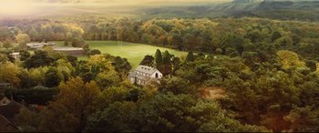 Movie still from “Kingsman: The Secret Service” (2014), directed by Matthew Vaughn – An aerial view of a house in the middle of a forest; Extreme Wide shot, High angle