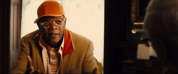 Movie still from “Kingsman: The Secret Service” (2014), directed by Matthew Vaughn – An older man wearing a yellow hat and a brown jacket; Close Up shot, Over the shoulder angle