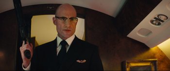 Movie still from “Kingsman: The Secret Service” (2014), directed by Matthew Vaughn – A bald man in a suit and tie; Close Up shot, Low angle