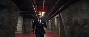 Movie still from “Kingsman: The Secret Service” (2014), directed by Matthew Vaughn – A man holding an umbrella while walking down a hallway; Medium shot, Low angle