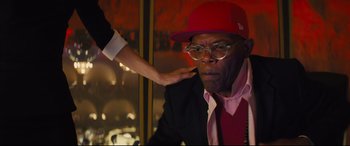 Movie still from “Kingsman: The Secret Service” (2014), directed by Matthew Vaughn – A person touching a man's face with a red hat on; Close Up shot, Over the shoulder angle