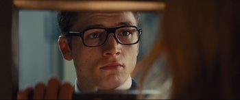 Movie still from “Kingsman: The Secret Service” (2014), directed by Matthew Vaughn – A young man wearing glasses looking into a mirror; Close Up shot, Over the shoulder angle
