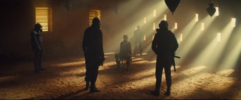 Movie still from “Kingsman: The Secret Service” (2014), directed by Matthew Vaughn – A group of people standing around in a room; Wide shot, Over the shoulder angle