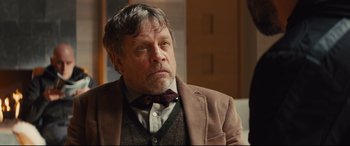 Movie still from “Kingsman: The Secret Service” (2014), directed by Matthew Vaughn – An older man wearing a brown jacket and a red tie; Close Up shot, Over the shoulder angle