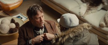 Movie still from “Kingsman: The Secret Service” (2014), directed by Matthew Vaughn – A man wearing a jacket and a hat is looking at another man; Medium shot, Over the shoulder angle