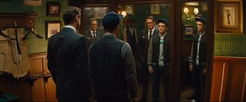 Movie still from “Kingsman: The Secret Service” (2014), directed by Matthew Vaughn – A group of men standing in front of a mirror; Medium shot, Over the shoulder angle