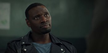 Movie still from “Lupin” (2021), created by Tigran Rosine – A man in a leather jacket looking up at the sky; Close Up shot, Over the shoulder angle