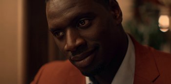 Movie still from “Lupin” (2021), created by Tigran Rosine – A man's face in a dark room; Close Up shot, Over the shoulder angle