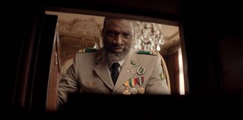 Movie still from “Lupin” (2021), created by Tigran Rosine – A man in a military uniform looking into a mirror; Medium shot, Low angle