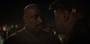 Movie still from “Lupin” (2021), created by Tigran Rosine – Two men talking to each other in the dark at night; Close Up shot, Over the shoulder angle