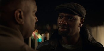 Movie still from “Lupin” (2021), created by Tigran Rosine – A man with a hat is talking to another man; Close Up shot, Over the shoulder angle