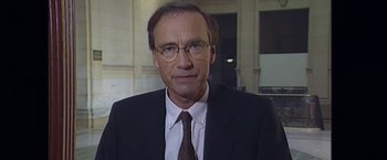 Movie still from “Madame Claude” (2021), directed by Sylvie Verheyde – A person wearing a suit and tie; Close Up shot, High angle