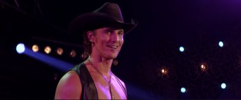 Movie still from “Magic Mike” (2012), directed by Steven Soderbergh – A man wearing a cowboy hat and a leather vest; Close Up shot, Over the shoulder angle