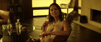 Movie still from “Magic Mike” (2012), directed by Steven Soderbergh – A woman sitting in a chair with a drink in her hand; Medium shot, Over the shoulder angle