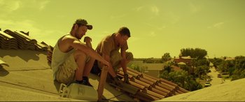 Movie still from “Magic Mike” (2012), directed by Steven Soderbergh – Two men working on a roof on a house; Medium shot, Low angle