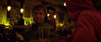 Movie still from “Magic Mike” (2012), directed by Steven Soderbergh – A man sitting at a table holding a glass of water; Close Up shot, Over the shoulder angle