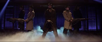 Movie still from “Magic Mike” (2012), directed by Steven Soderbergh – A group of men wearing trench coats and hats; Wide shot, Low angle
