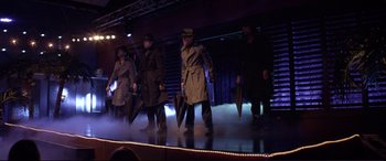Movie still from “Magic Mike” (2012), directed by Steven Soderbergh – A group of people on a stage holding umbrellas; Wide shot, Low angle