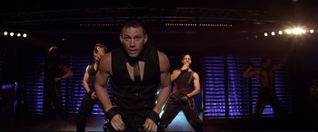 Movie still from “Magic Mike” (2012), directed by Steven Soderbergh – A group of men performing on a stage; Medium shot, Over the shoulder angle