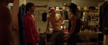 Movie still from “Magic Mike” (2012), directed by Steven Soderbergh – A group of young men standing in a kitchen; Medium shot, Over the shoulder angle