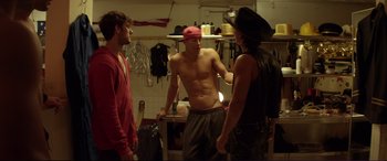Movie still from “Magic Mike” (2012), directed by Steven Soderbergh – A group of men standing around in a kitchen; Medium shot, Over the shoulder angle