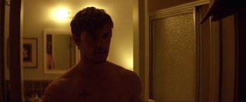 Movie still from “Magic Mike” (2012), directed by Steven Soderbergh – A man with a cross on his chest in a bathroom; Close Up shot, Over the shoulder angle