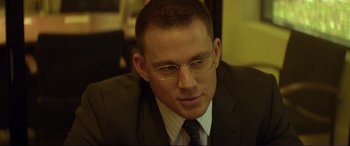 Movie still from “Magic Mike” (2012), directed by Steven Soderbergh – A person wearing a suit and glasses; Close Up shot, Over the shoulder angle