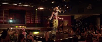 Movie still from “Magic Mike” (2012), directed by Steven Soderbergh – A man in yellow pants standing on a stage; Wide shot, Over the shoulder angle