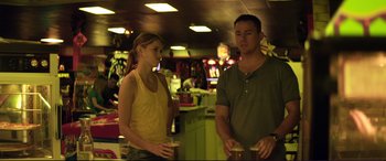 Movie still from “Magic Mike” (2012), directed by Steven Soderbergh – A man and a woman standing next to each other holding drinks; Medium shot, Over the shoulder angle
