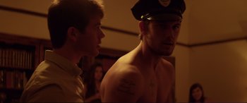 Movie still from “Magic Mike” (2012), directed by Steven Soderbergh – A man in a police hat and a man in a white shirt; Medium shot, Over the shoulder angle