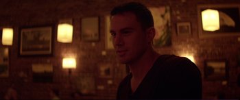 Movie still from “Magic Mike” (2012), directed by Steven Soderbergh – A man in a dark room looking at the camera; Close Up shot, Over the shoulder angle