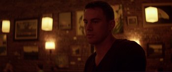 Movie still from “Magic Mike” (2012), directed by Steven Soderbergh – A man is standing in a dark room; Close Up shot, Over the shoulder angle