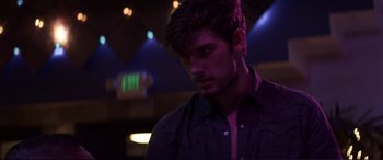 Movie still from “Magic Mike” (2012), directed by Steven Soderbergh – A young man in a black shirt is in a dark room; Close Up shot, Over the shoulder angle