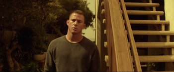 Movie still from “Magic Mike” (2012), directed by Steven Soderbergh – A man standing in front of a wooden structure; Medium shot, Low angle