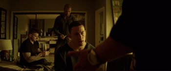 Movie still from “Magic Mike” (2012), directed by Steven Soderbergh – A man holding a nintendo wii game controller in front of another man in a room; Medium shot, Over the shoulder angle