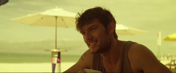 Movie still from “Magic Mike” (2012), directed by Steven Soderbergh – A person sitting at a table with a drink; Close Up shot, Over the shoulder angle