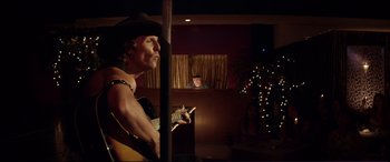 Movie still from “Magic Mike” (2012), directed by Steven Soderbergh – A man in a cowboy hat is holding a guitar; Medium shot, Over the shoulder angle
