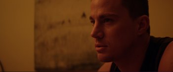 Movie still from “Magic Mike” (2012), directed by Steven Soderbergh – A man's face in a dark room; Close Up shot, Low angle