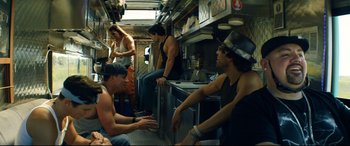 Movie still from “Magic Mike XXL” (2015), directed by Gregory Jacobs – A group of men sitting around in a kitchen; Medium shot, Low angle