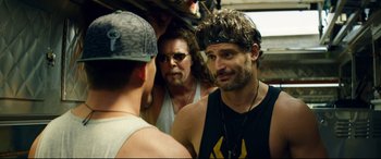 Movie still from “Magic Mike XXL” (2015), directed by Gregory Jacobs – A group of men standing next to each other on a street; Close Up shot, Over the shoulder angle