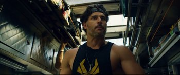 Movie still from “Magic Mike XXL” (2015), directed by Gregory Jacobs – A man in a black tank top is looking at the camera; Close Up shot, Low angle