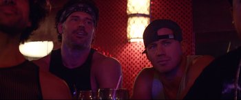 Movie still from “Magic Mike XXL” (2015), directed by Gregory Jacobs – A couple of men sitting next to each other at a table; Close Up shot, Over the shoulder angle