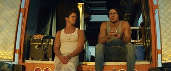 Movie still from “Magic Mike XXL” (2015), directed by Gregory Jacobs – Two young men sitting on the back of a truck; Medium shot, Low angle